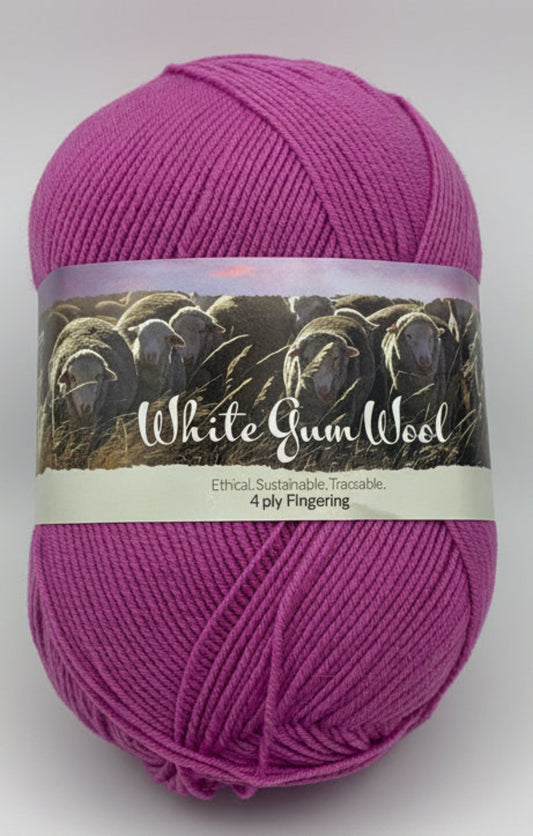 Mid-pink "Peachberry" ball of superfine 4 ply Merino wool on white background