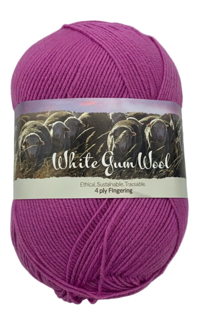 Mid-pink "Peachberry" ball of superfine 4 ply Merino wool on white background
